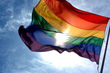 1280px-Rainbow_flag_and_blue_skies-min-600×399