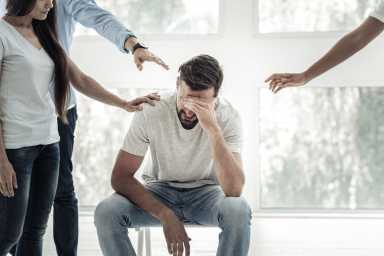 Depressed young man covering his eyes