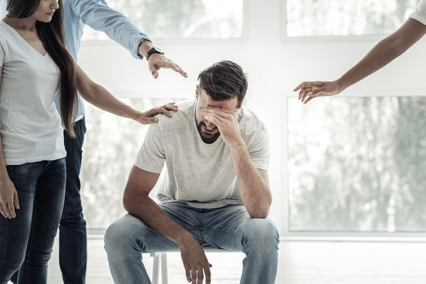 Depressed young man covering his eyes