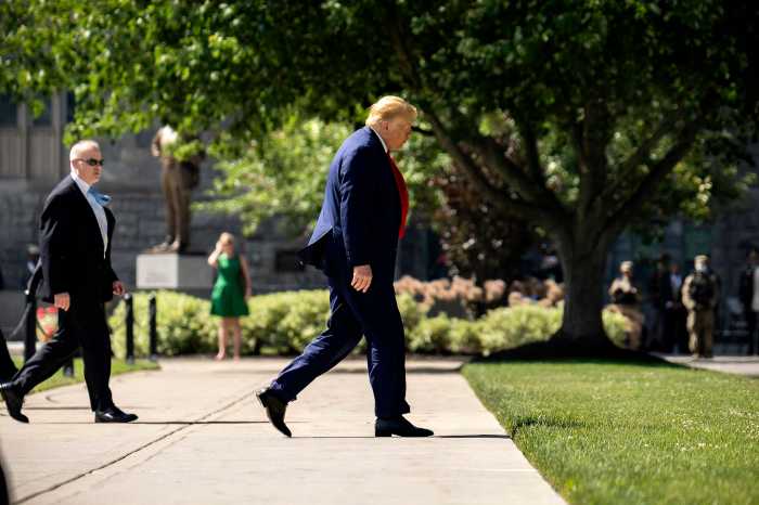 Donald Trump walking with his head down with a security guard behind him. (Tsubasa Berg)