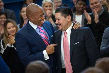 Brooklyn Borough President Eric Adams with Schools Chancellor Richard A. Carranza surrounded by adults clapping hands.