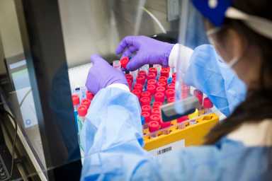 A woman lab worker opening a test tube