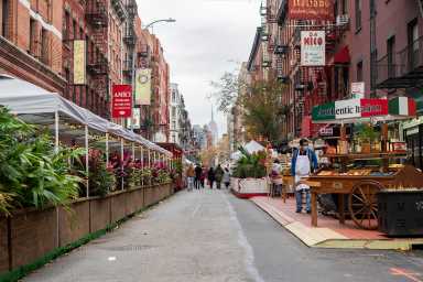 A street in LIttle Italy with Sidewalk Seating areas on each side (Photo by Tsubasa Berg)