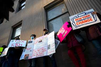 Protesters holding signs that read "Tax the Rich" "New York Communities for Change" among many others in front of the 740 Park Avenue building