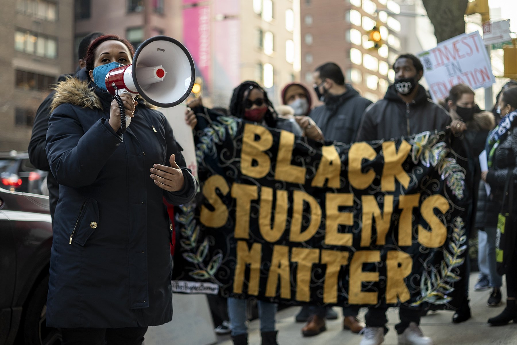 City Council District 10 candidate Johanna Garcia on megaphone and "Black Students Matter" banner behind her held by activists
