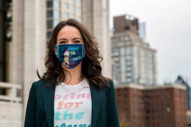 Sara Lind smiling for the camera with a colorful mask with Ruth Bader Ginsberg illstration and a text that reads "FIGHT FOR THE THINGS YOU CARE ABOUT"