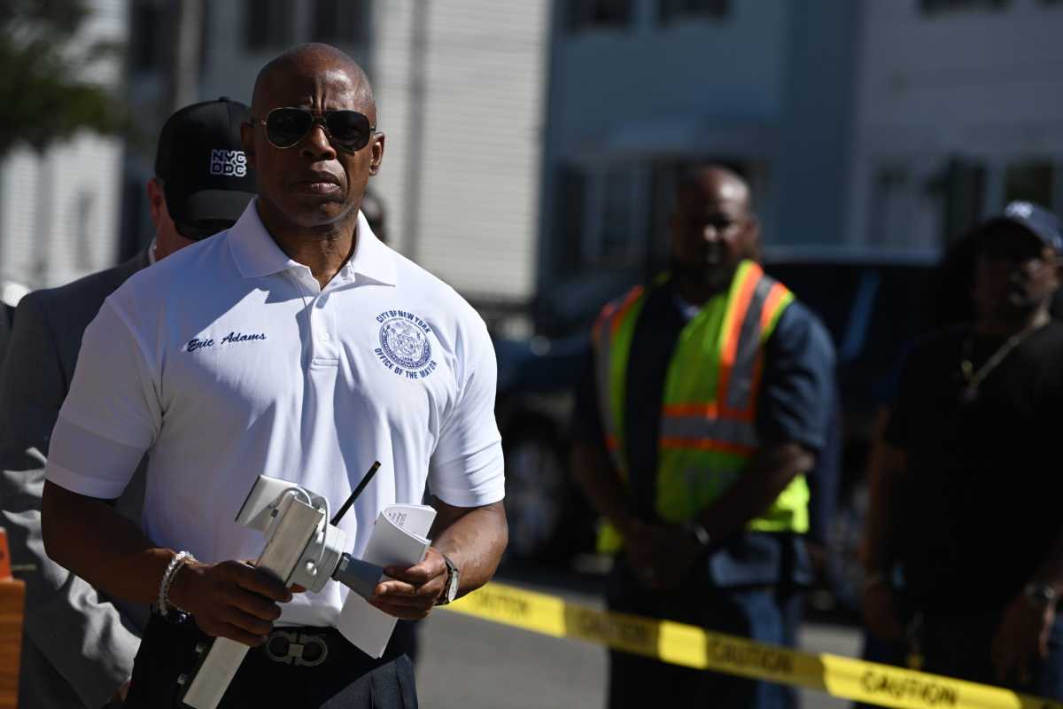 Mayor Eric Adams holds onto the device.